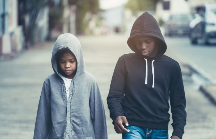  Boy and girl walking down the street with hoods on